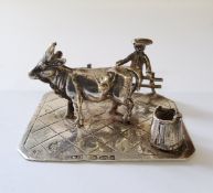 A German silver miniature of a young farmer sat on a fence with his cow & milk pail, stamped 930,