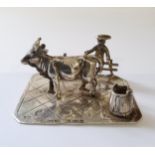 A German silver miniature of a young farmer sat on a fence with his cow & milk pail, stamped 930,