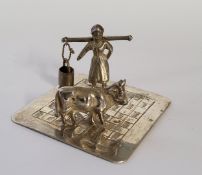A Dutch silver miniature of a milk maid and cow on a square base engraved with paving slabs, maker