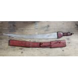 A large South African tribal sword in embossed red leather sheath, the curved blade etched with