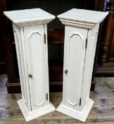 A pair of painted plinths with door to the body of the column, revealing shelves.