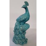 A large turquoise glazed model of a peacock, impressed marks to base, standing 43cm high.