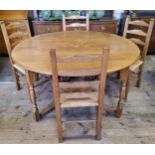 A Nigel Griffiths English oak circular gate leg drop leaf dining table with four matching rush