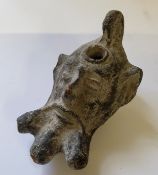 A Roman military clay oil lamp depicting the mask of Pan with small pierced loop handle, pouring