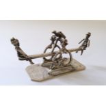 A Dutch silver miniature of two children on a see-saw, with bird percehd centrally, indistinct mark,