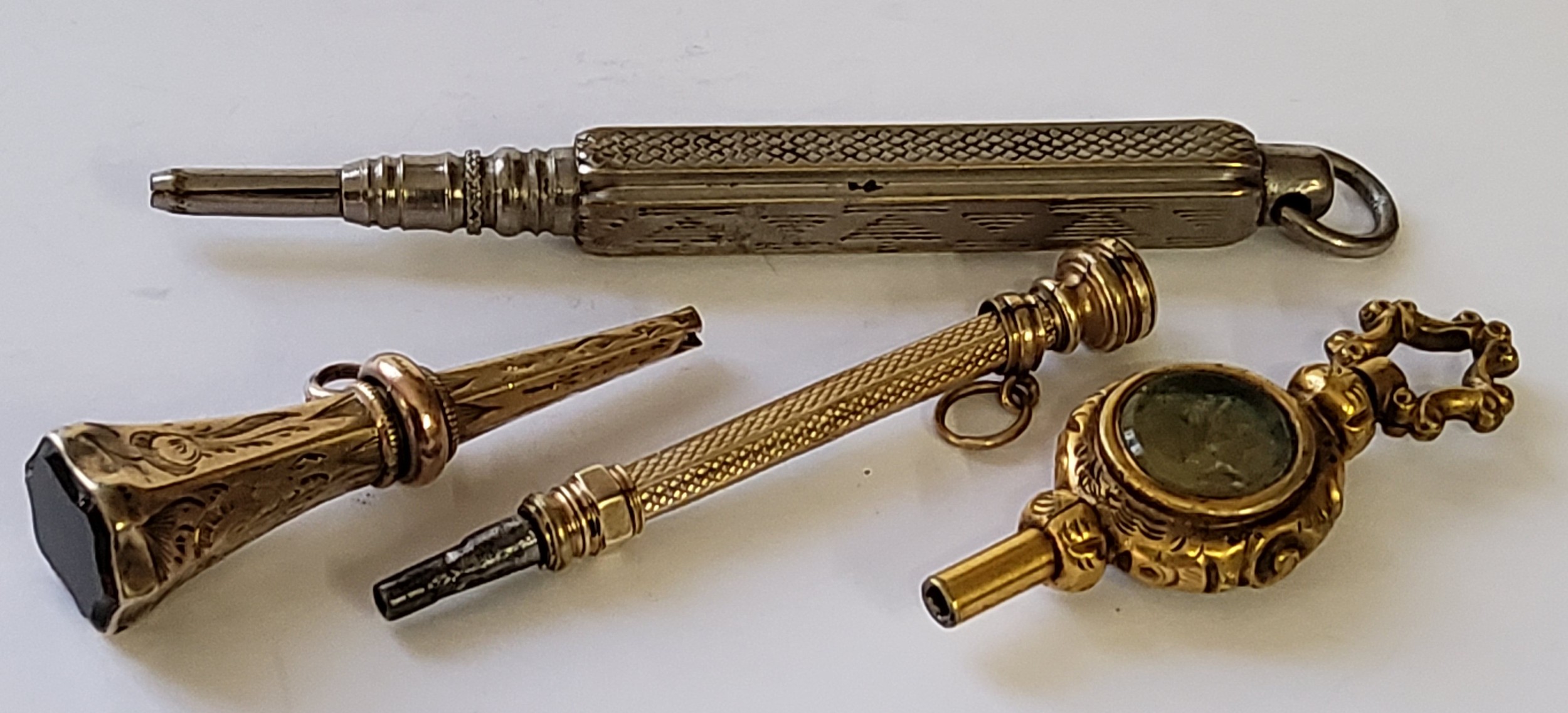 A Victorian gilt metal pocket watch key; a Victorian yellow metal slide pencil fob, set with a