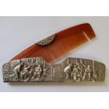 A Dutch silver comb cover embossed in relief with a village scene stamped Denmark and dolphin