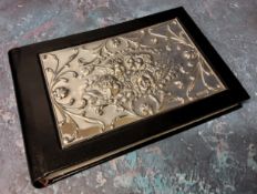 A silver mounted black leather guest book, the silver panel embossed in relief with Reynolds Angels,