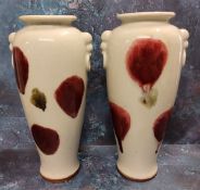 A pair of Japanese tapering cylindrical pottery vases, decorated in sang de beouf with dripped