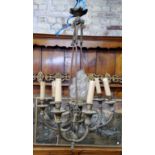 A French gilt metal chandelier with central frosted glass torch / flame finial, showing signs of