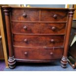 A Victorian mahogany flame mahogany bow front chest, of two short and three long drawers, turned