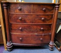 A Victorian mahogany flame mahogany bow front chest, of two short and three long drawers, turned