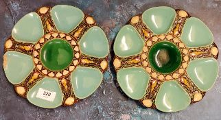 A pair of Minton majolica oyster dishes, moulded with a central circular well radiating six