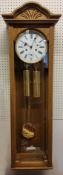 A Hermle oak finish regulator wall clock with 1/2 hour strike, 8 day cable driven movement, white