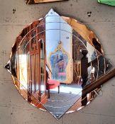 A substantial Art Deco shaped circular mirror, with peach coloured glass to the quarters,