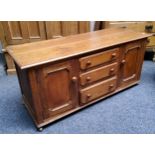 A Titchmarsh and Goodwin style English oak side unit, with three long graduated drawers flanked by a