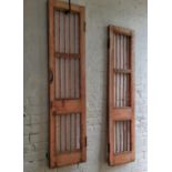 A near pair of French painted doors finished in a pink, distressed finish with iron railings,