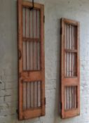 A near pair of French painted doors finished in a pink, distressed finish with iron railings,