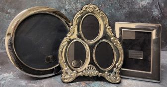 A silver mounted trefoil photograph frame, embossed in relief decoration, velvet backed, Ron Carr,