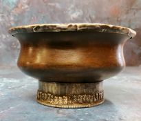 A Tibetan white metal mounted indigenous timber circular libation bowl, raised foot ring, 10cm diam