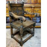 A '17th century' Wainscot type country house hall chair, ecclesiastical in taste. Carved panel