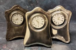 Two silver mounted miniature clocks in form of a shaped mantel clock, wood backed, an embosed and