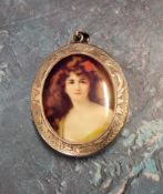A large oval silver locket the central raised panel set with an image of a maiden, engraved and