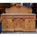 A Victorian farmhouse pine sideboard, the carved super-structure above stepped surface, three