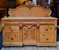 A Victorian farmhouse pine sideboard, the carved super-structure above stepped surface, three