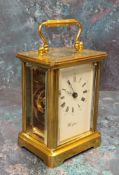 A brass carriage clock, 11 jewel movement, bevelled glass and small top panel, white dial, black