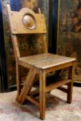 An early 20th century oak Arts and Crafts metamorphic library chair/steps, the back with roundel,