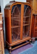 An Art Deco oak display cabinet, adjustable shelves, refectory stretcher, fluted pad feet c.1940,