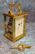 A brass carriage clock, 11 jewel movement, bevelled glass and small top panel, white dial, black