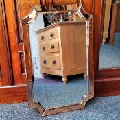 An Art Deco shaped rectangular mirror, concave canted corners, peach coloured glass border. 74cm h x