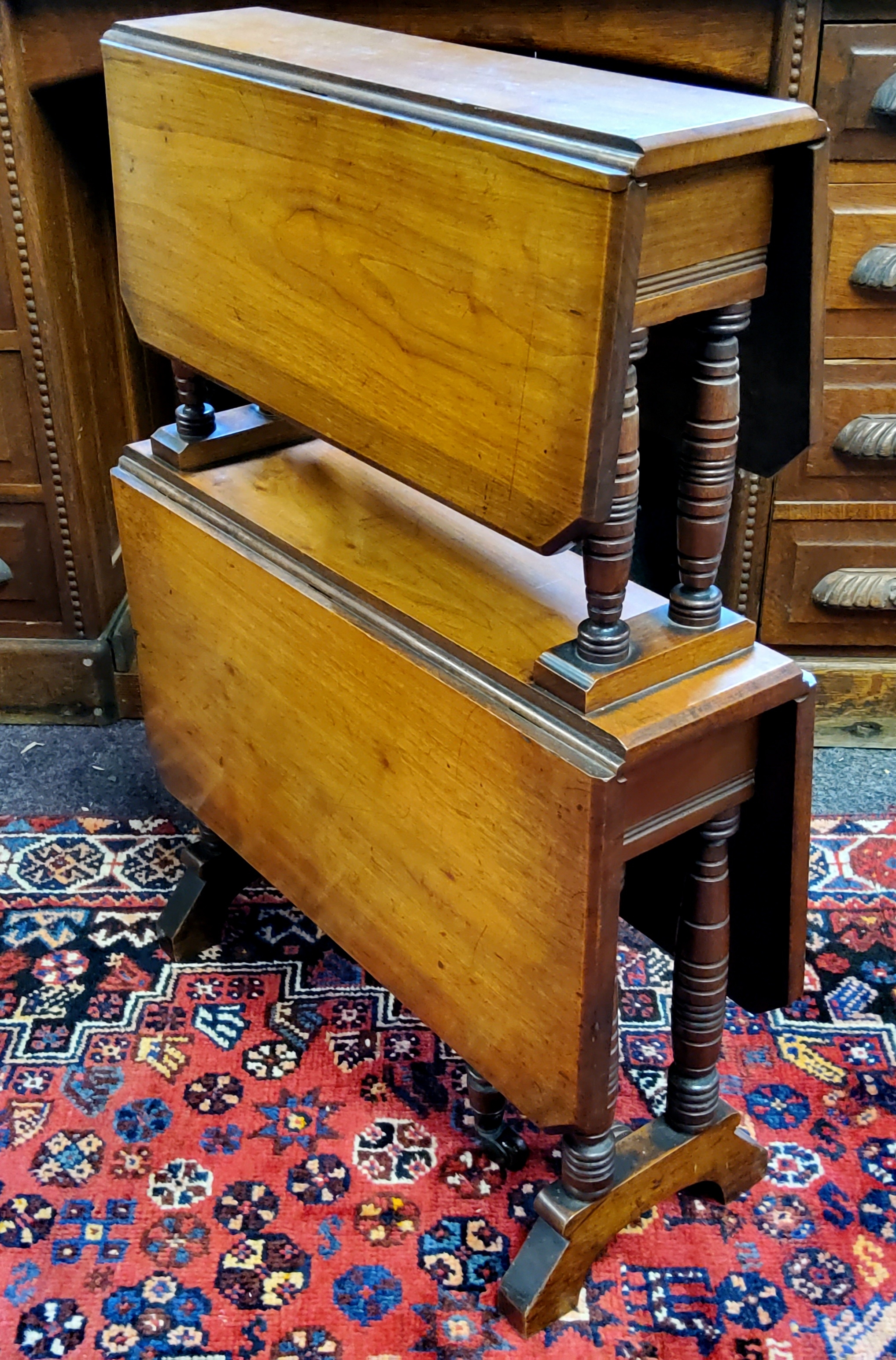 A Victorian walnut two-tier Sutherland gateleg occasional table, each with canted corners on