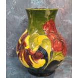 A Moorcroft Hibiscus pattern baluster vase, tube lined with large flowerheads,  in tones of red on a