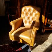 A Laura Ashley deep button backed armchair, cowhide upholstery, turned mahogany feet