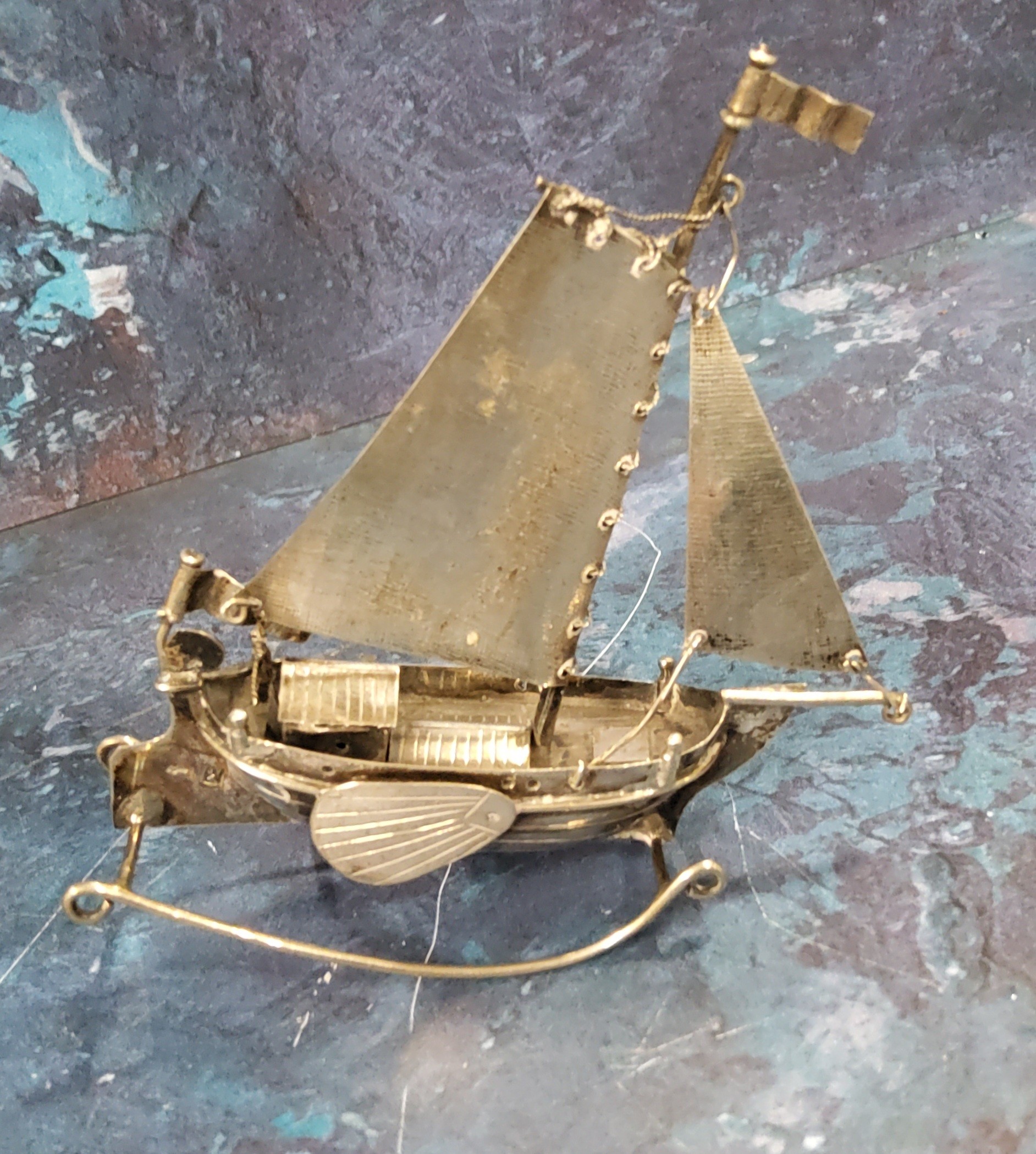 A Dutch silver coloured metal model, of a boat on rocker, 9.5cm high