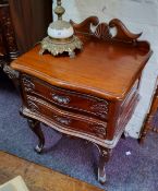 A reproduction mahogany bedside chest of two long drawers raised on acanthus capped cabriole legs