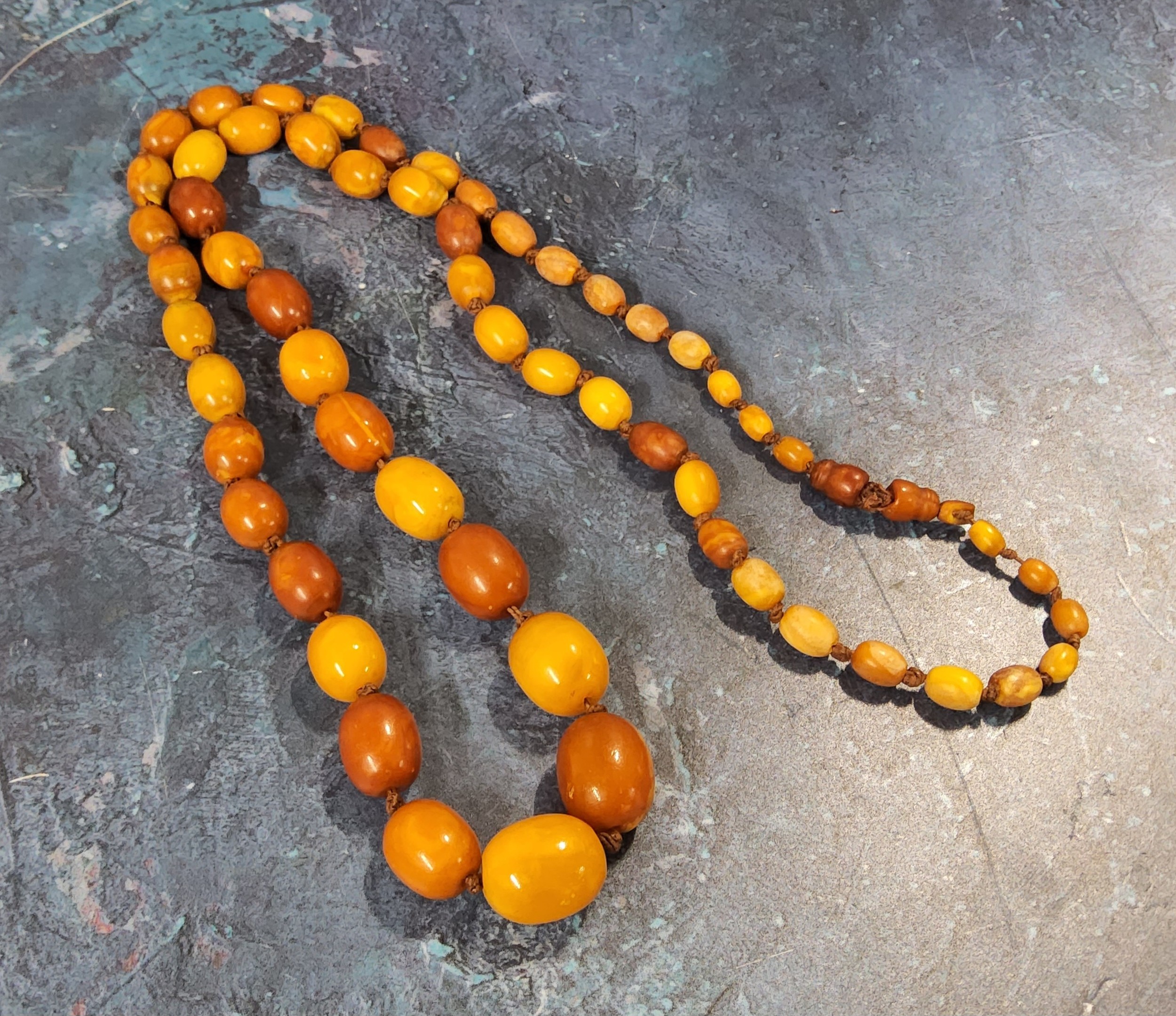 A 86cm string of oval butterscotch amber beads, total weight 50.7g