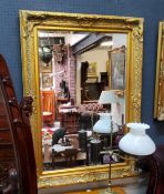 A decorative gilt framed bevelled edge mirror, 111cm high x 80cm wide