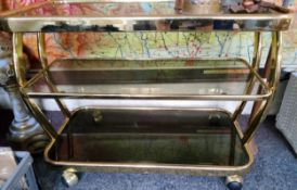 A contemporary gilt metal and smoked glass three tier trolley, 80cm wide, 63cm high