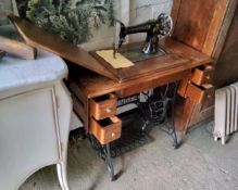 An early 20th century Singer sewing machine trestle table