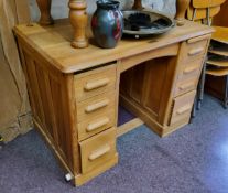 A light oak knee hole desk, central blind drawer to frieze flanked by slide-outs above four drawers,