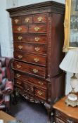 A reproduction Chippendale style hardwood chest on stand of thirteen drawers, the base with one long