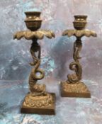 A pair of Regency bronze candlesticks, everted leafy sconces, dolphin columns, square bases, 18.