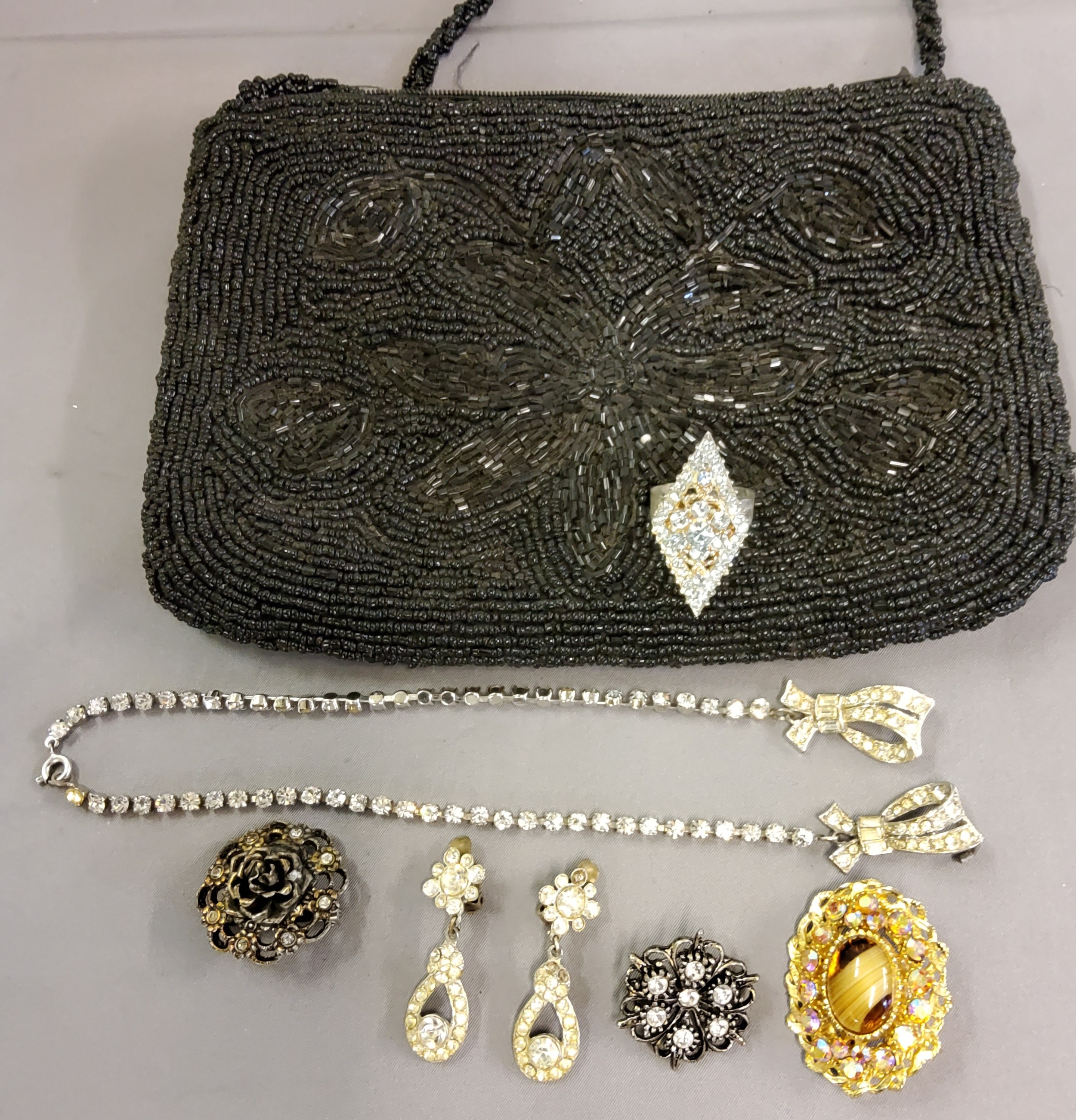 A lady's sequin evening bag;  fashion brooches, rings, etc