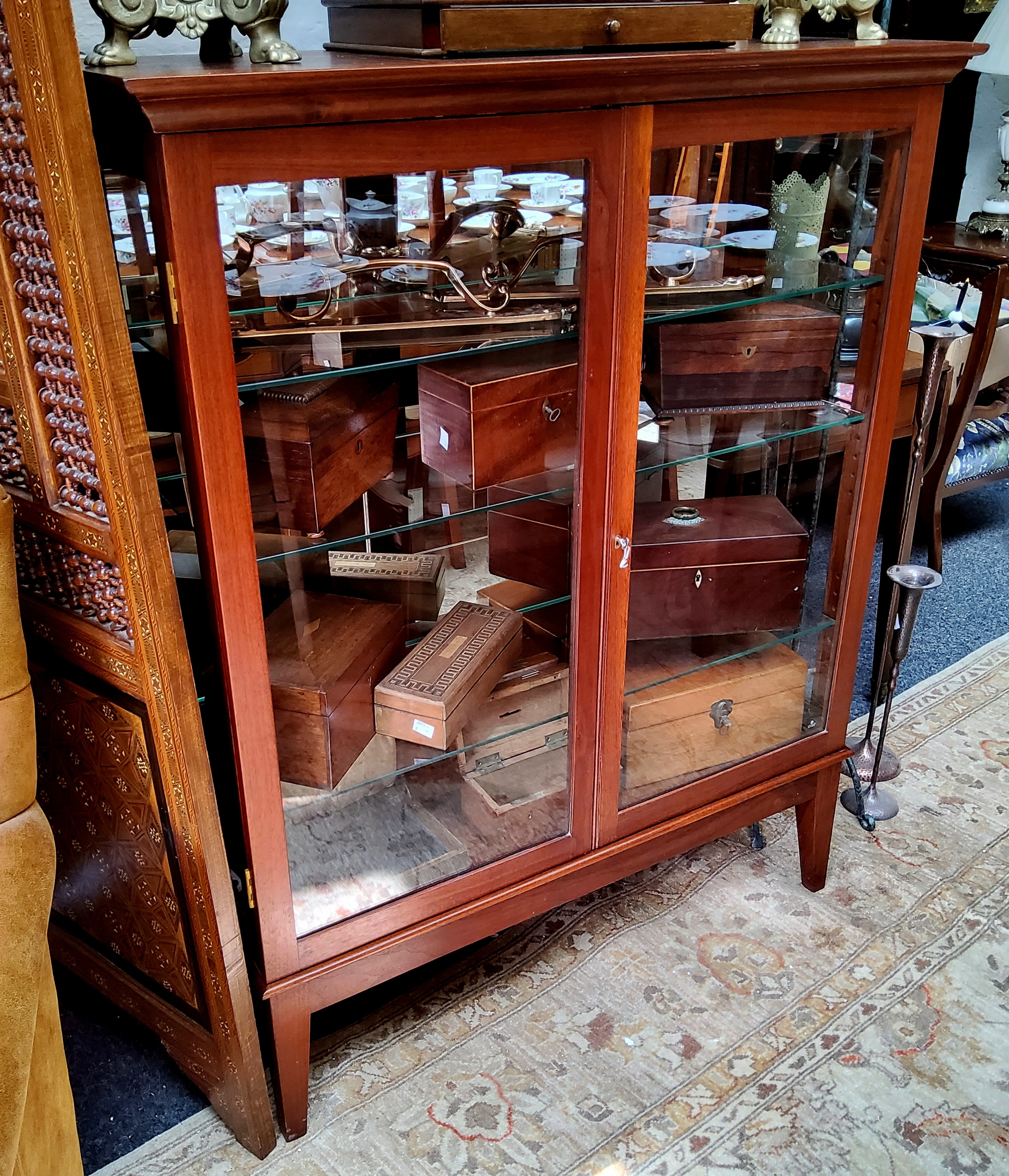 A recently commissioned mirror backed display cabinet, oversailing surface with two glazed doors