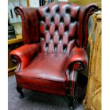 A Chesterfield wing back armchair, oxblood red, good condition