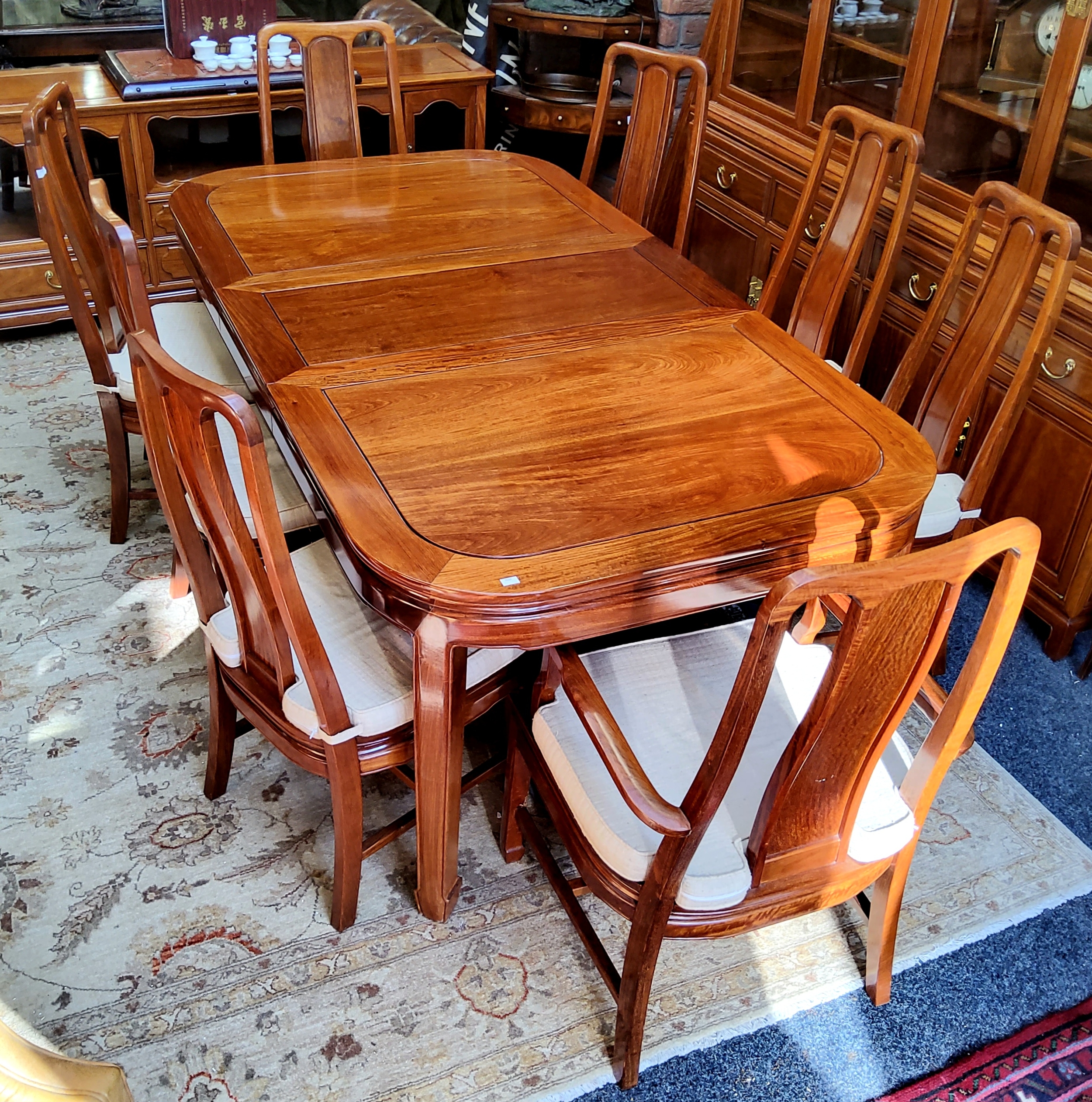 A Chinese hardwood draw leaf dining table with two carvers, six dining chairs and additional leaf,